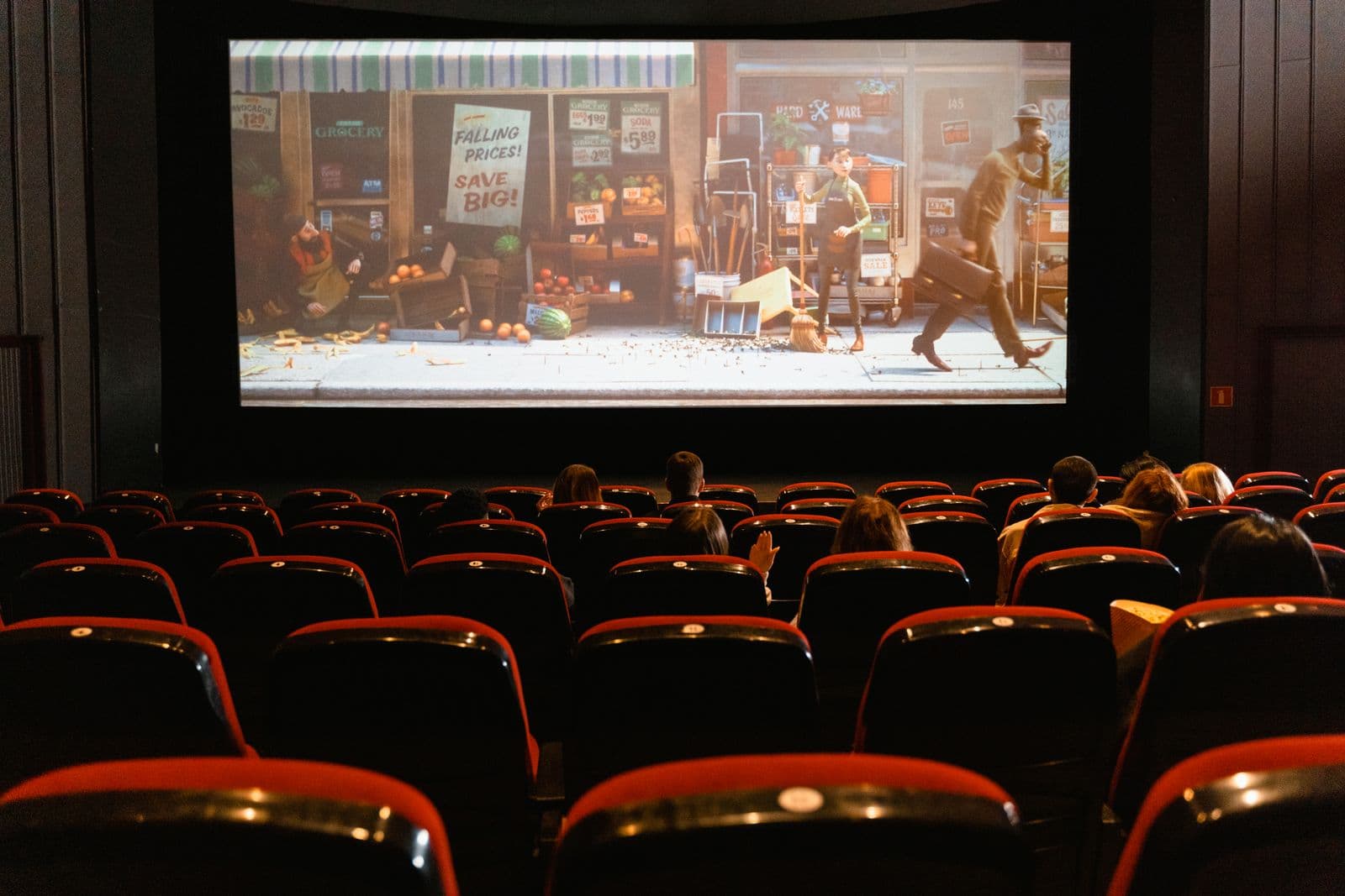 Karanlık sinema salonunda büyük perdede film izleyen izleyiciler